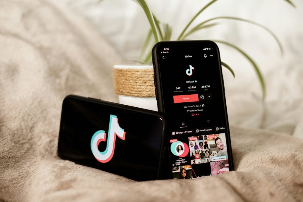 Professional creator analyzing TikTok video growth and engagement metrics on a smartphone in a modern content creation workspace.