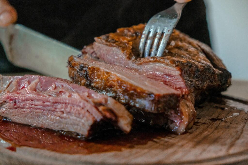 Juicy prime rib roast and grilled ribeye steak served side by side, highlighting differences in texture, marbling, cooking style, and steakhouse presentation.