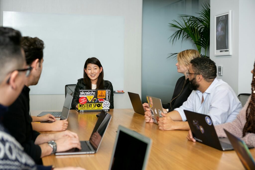 HR manager onboarding a new employee during a team orientation meeting in a modern workplace environment.