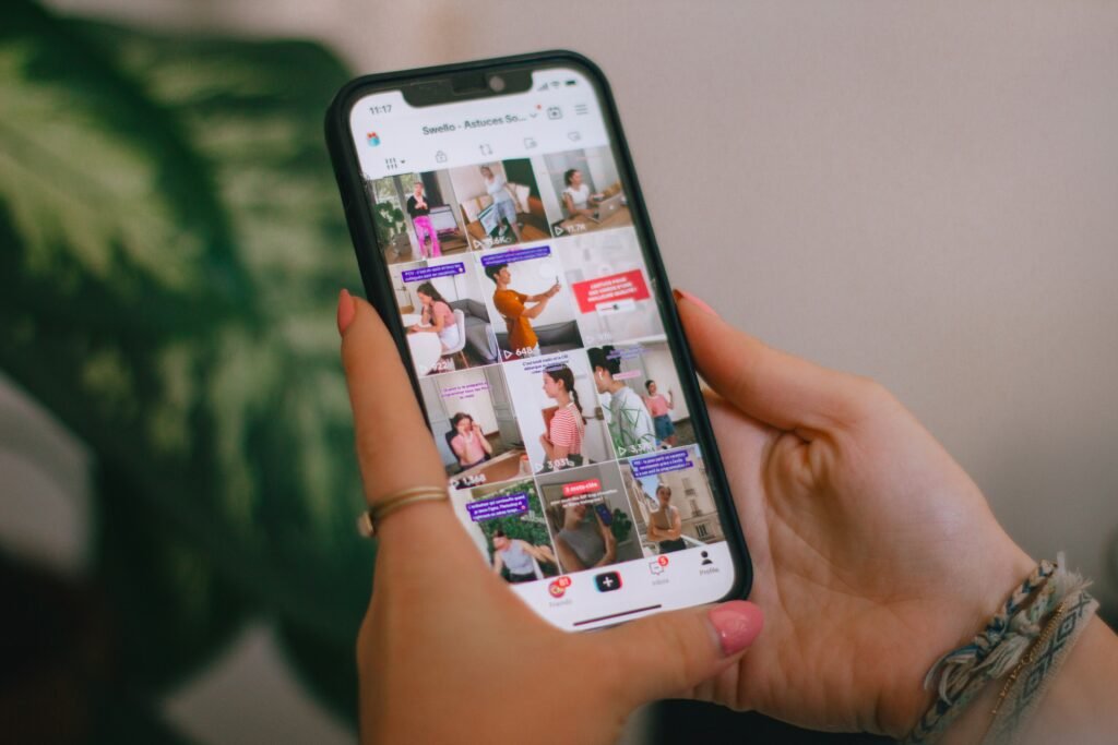Professional TikTok creator analyzing follower growth and engagement metrics on a smartphone in a modern UK-inspired content creation workspace.