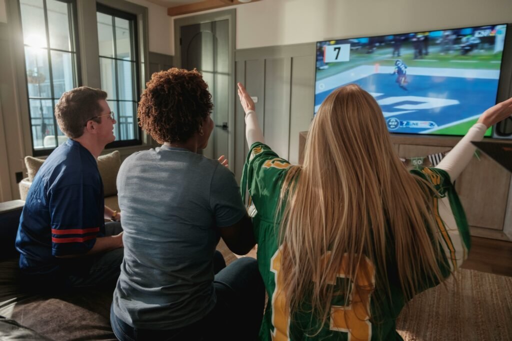 Multiple sports streaming platforms displayed on smart TVs and mobile devices, featuring live sports broadcasts, scoreboards, and digital viewing technology.