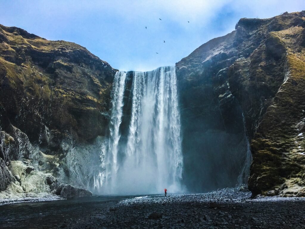 Travelers exploring Iceland's waterfalls, glaciers, black sand beaches, and geothermal lagoons under dramatic Nordic landscapes