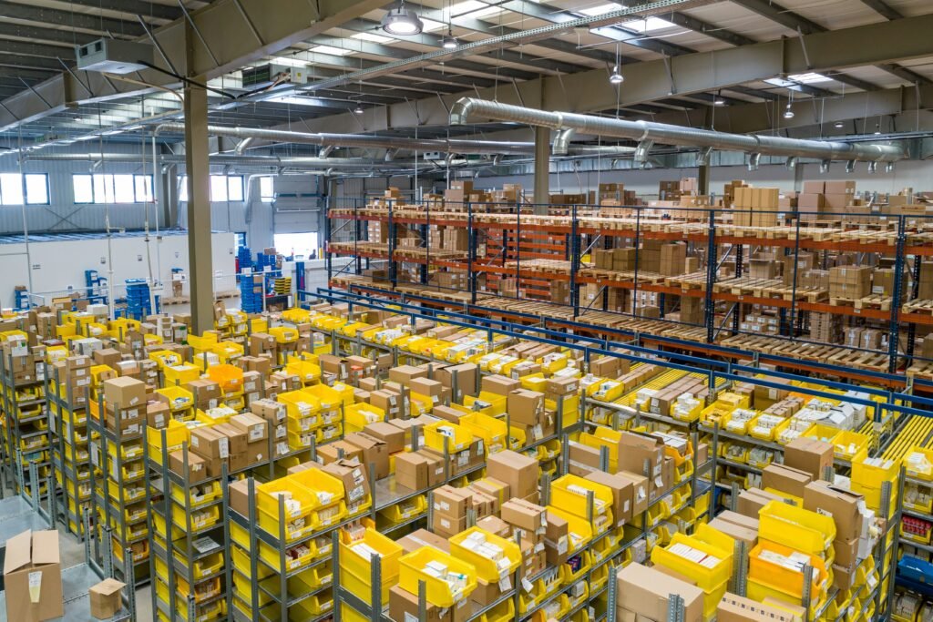 Business owner pushing a shopping cart through a wholesale warehouse with bulk products and business supplies.